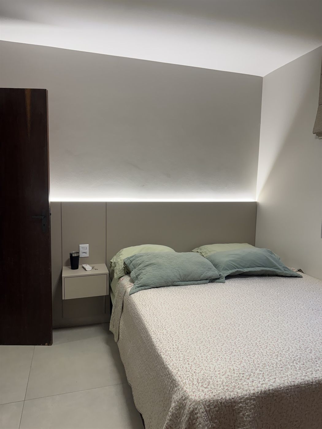 Quarto planejado com cabeceira estofada, LED e criado-mudo suspenso